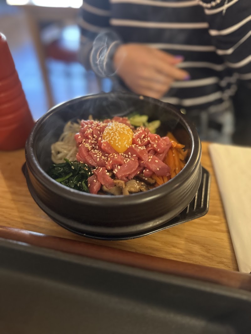 Bibimbap servi dans un bol de pierre chaude avec bœuf et légumes